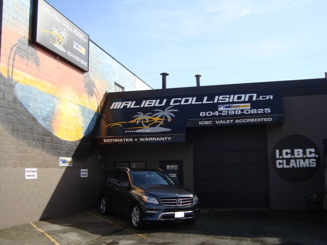 The Malibu Collision shop front on East 1st Avenue, with the painted palm mural, the ICBC Valet Accredited sign and the ICBC claims bay